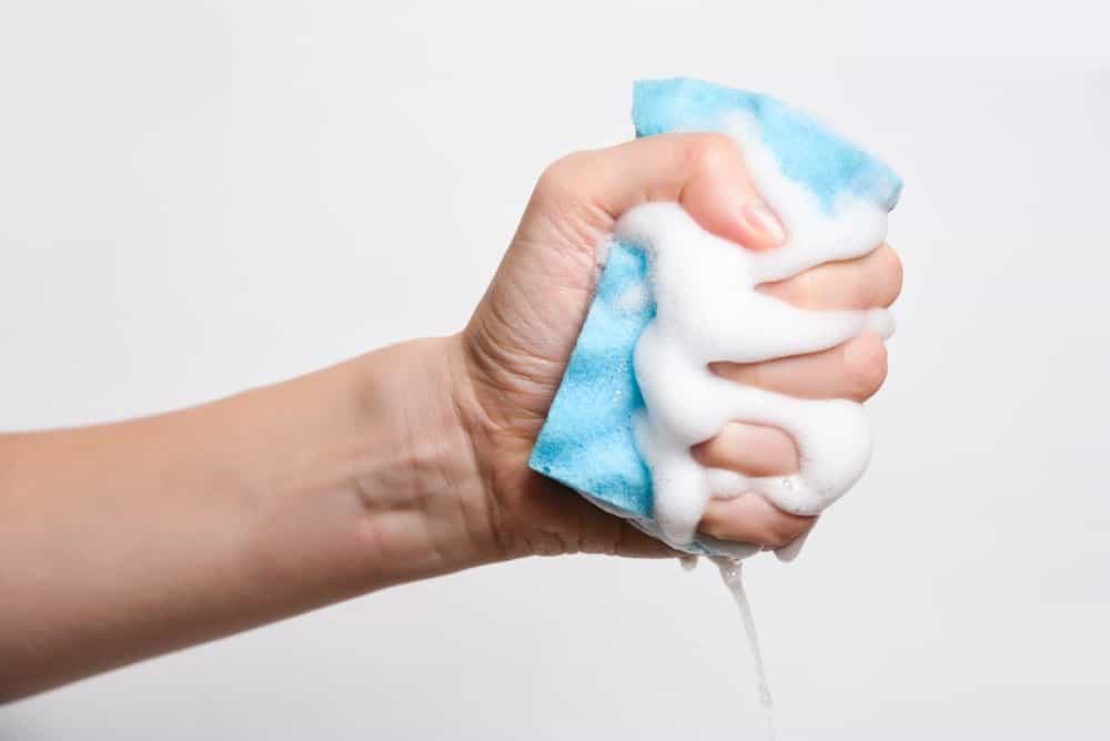 Una mano está apretando la esponja
