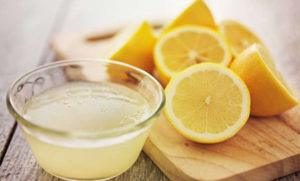 Algunos limones con jugo de limón en la mesa
